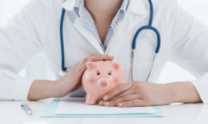 Doctor holding a piggy bank